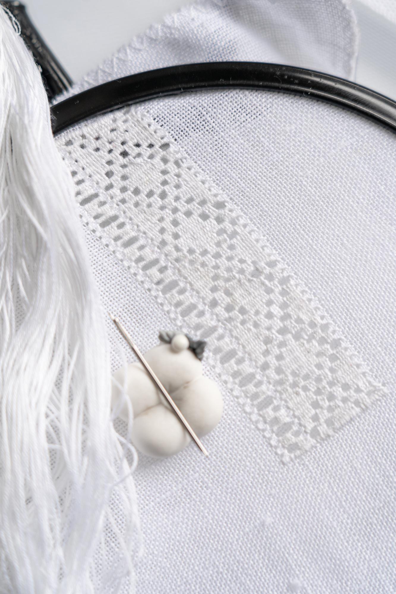 hands stitching floral motif on linen